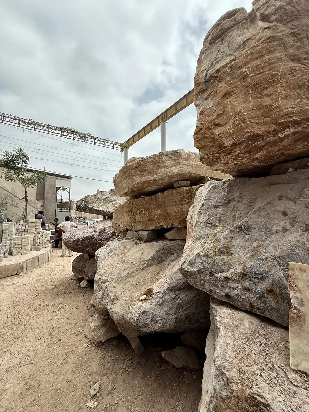 Unprocessed natural stone blocks stored outdoors at the manufacturing yard